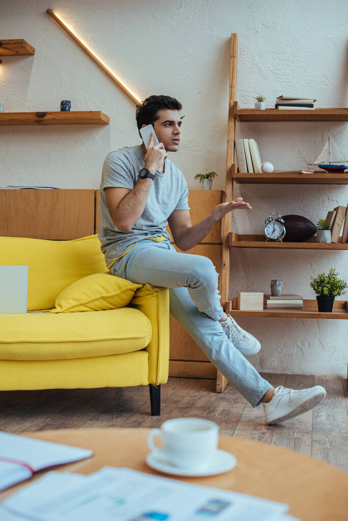 Szelektív fókusz a szabadúszó beszél okostelefon kanapén a nappaliban - Fotó, kép