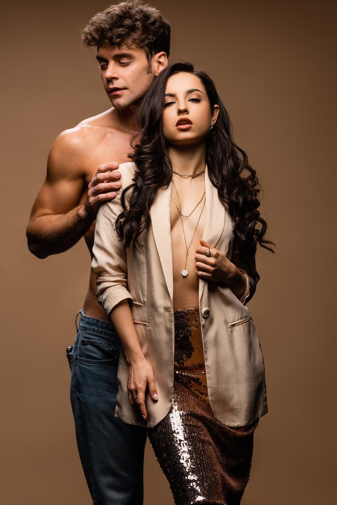 sensual shirtless boyfriend hugging passionate half naked girlfriend in beige jacket on beige - Photo, Image