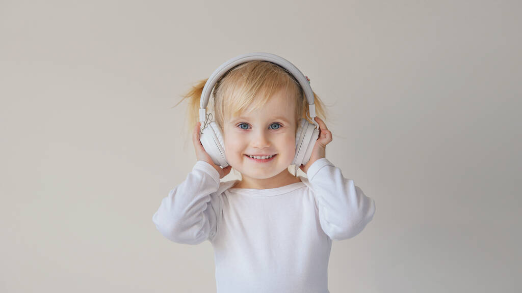 home, technology and music concept - little girl with headphones listening to music and singing - Photo, Image