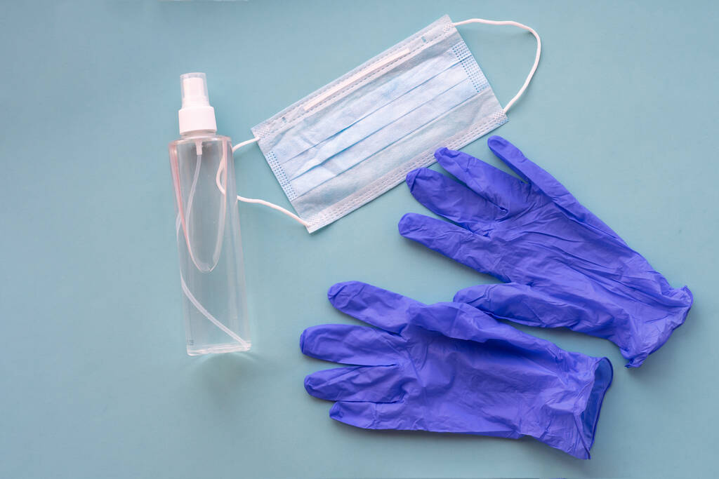 Top view of health care medical things as mask, gloves and spray bottle with antiseptic. Crisis due to coronavirus COVID-19 quarantine. Concept of health care and personal hygiene. - Photo, Image