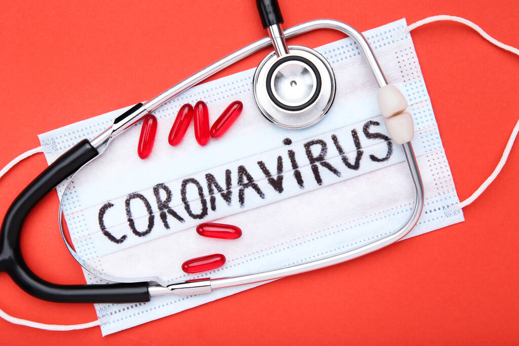 Szöveg Coronavirus tabletták és sztetoszkóp piros alapon - Fotó, kép