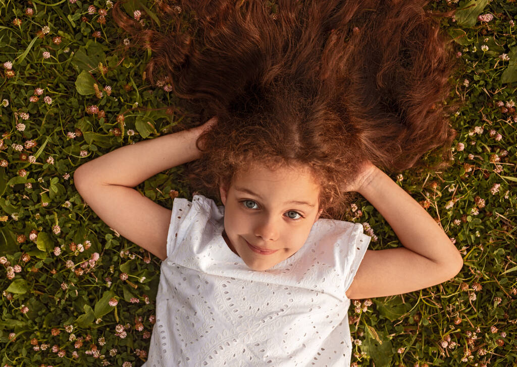 маленька дівчинка лежить на траві
 - Фото, зображення
