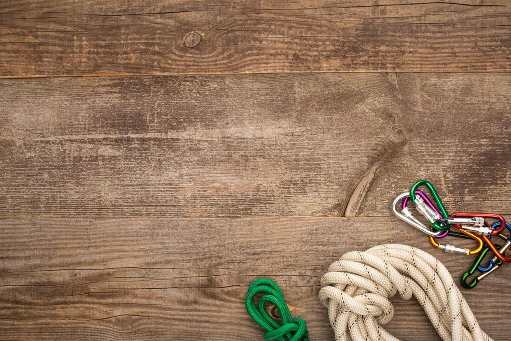 pohled shora na turistická lana a karabiny na dřevěném stole - Fotografie, Obrázek