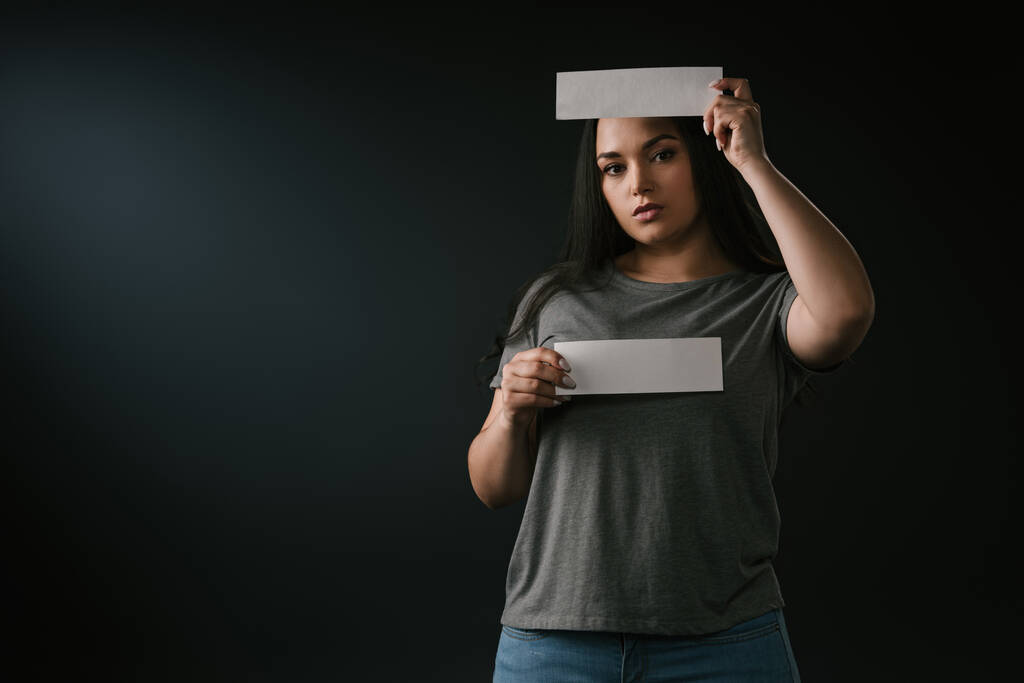 Вид спереди симпатичной девушки с пустыми карточками для копирования на чёрном фоне
  - Фото, изображение