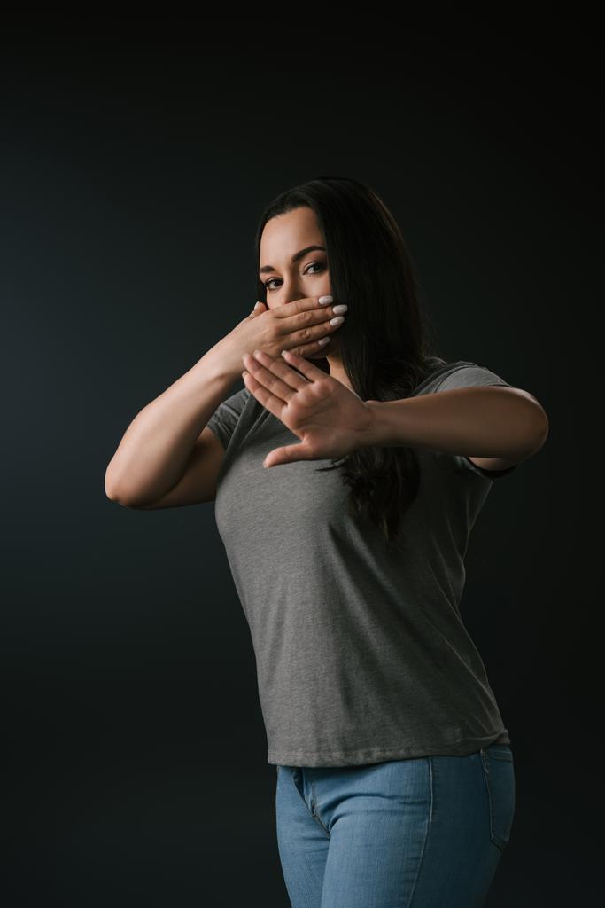 Plus size girl expressing silence with stop gesture isolated on black - Photo, Image