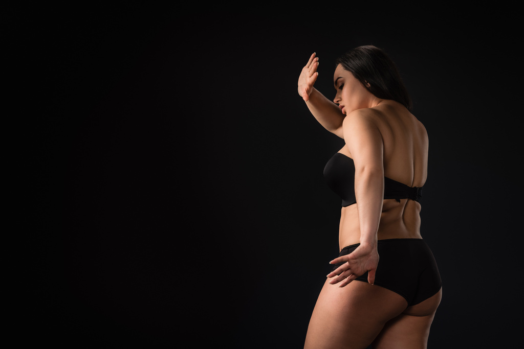 Plus tamaño chica ocultando su cuerpo y mostrando stop gesto aislado en negro
 - Foto, Imagen