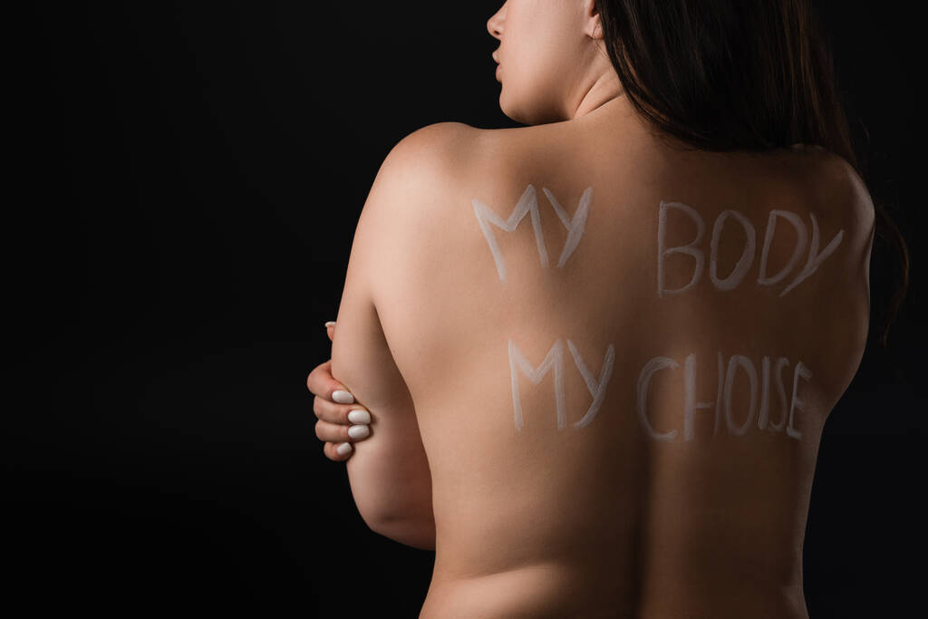 Back view of plus size model with lettering My Body My Choice on naked back isolated on black  - Photo, Image