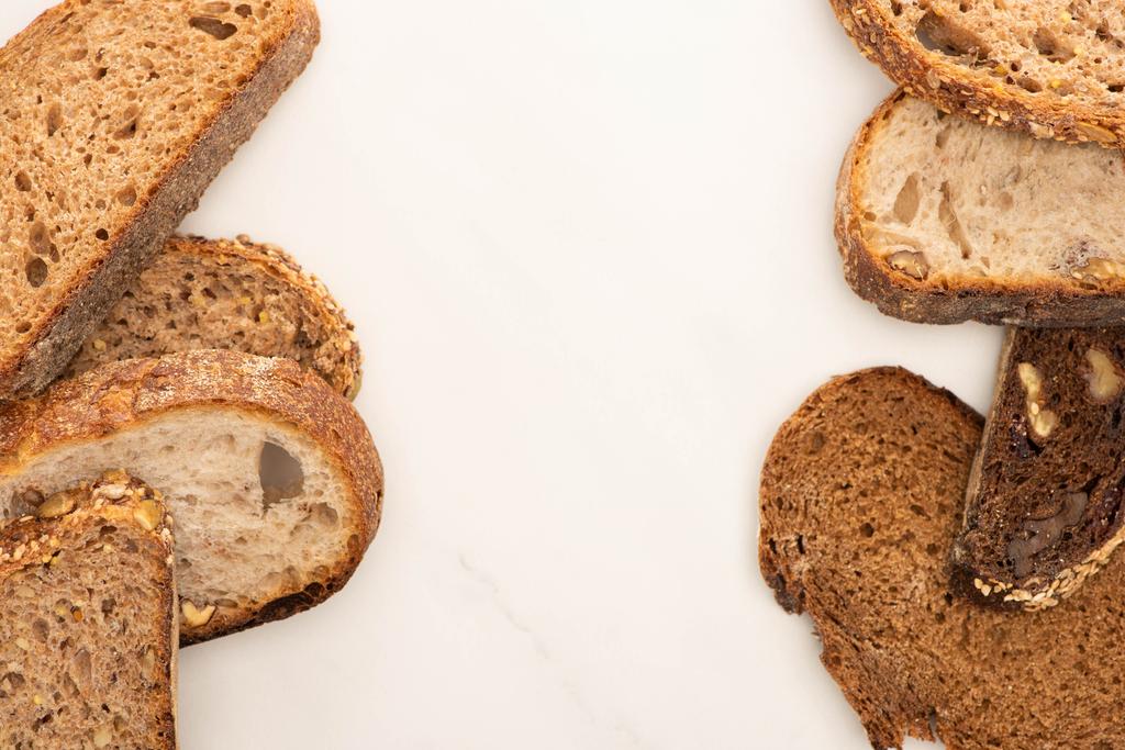 felső nézet friss teljes kiőrlésű kenyérszeletek fehér háttér másolási hely - Fotó, kép