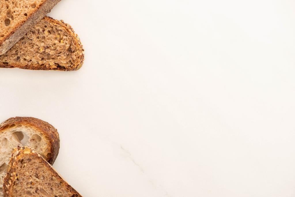 vue de dessus des tranches de pain de grains entiers frais sur fond blanc avec espace de copie
 - Photo, image