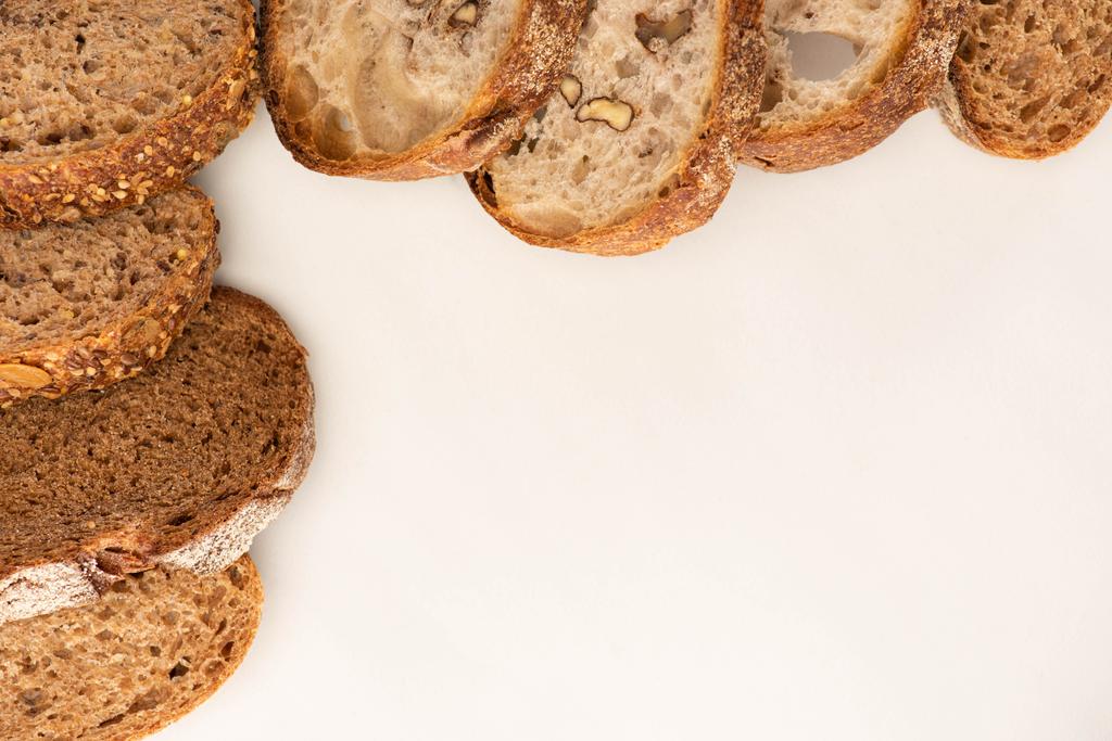 vista superior de fatias de pão de trigo integral fresco no fundo branco com espaço de cópia
 - Foto, Imagem