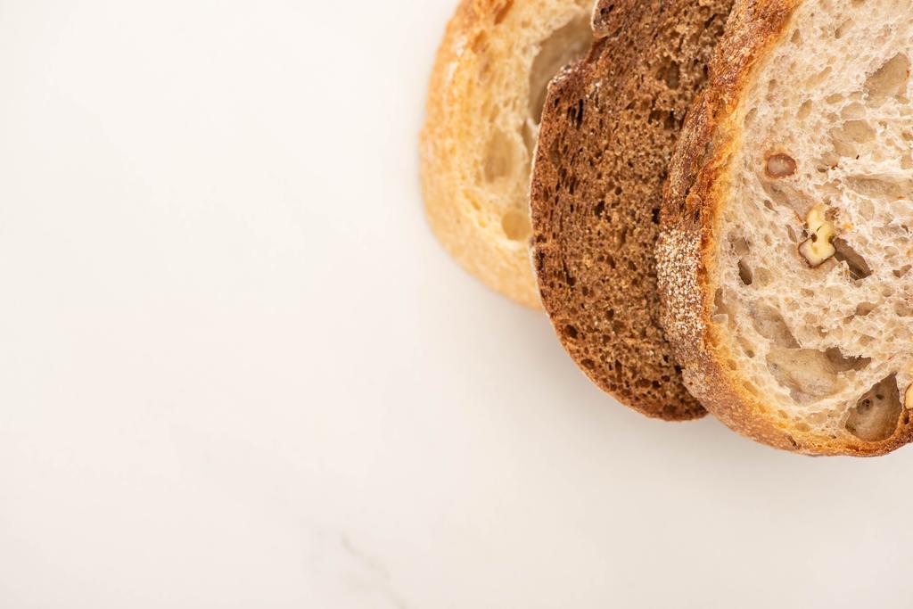 Draufsicht auf frische Brotscheiben auf weißem Hintergrund mit Kopierraum - Foto, Bild