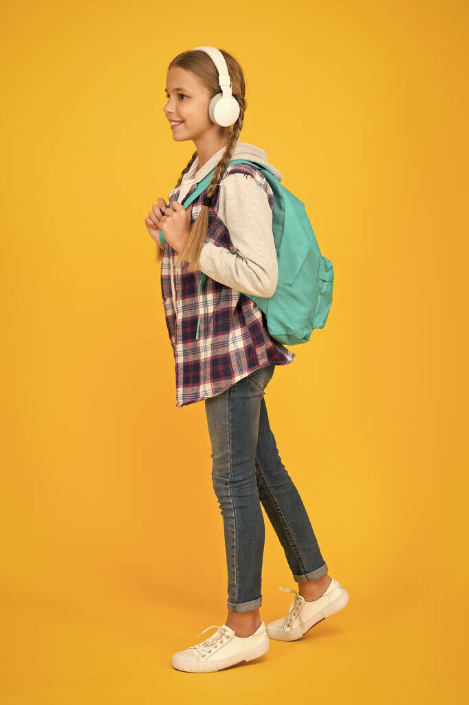 Prozkoumejte možnosti. Hipsterová se stará o batoh. školní taška. Podzimní dětská móda. dítě poslouchat hudbu sluchátka. vzdělávání a vývoj v dětství. Šťastný dětský den. audio kniha - Fotografie, Obrázek