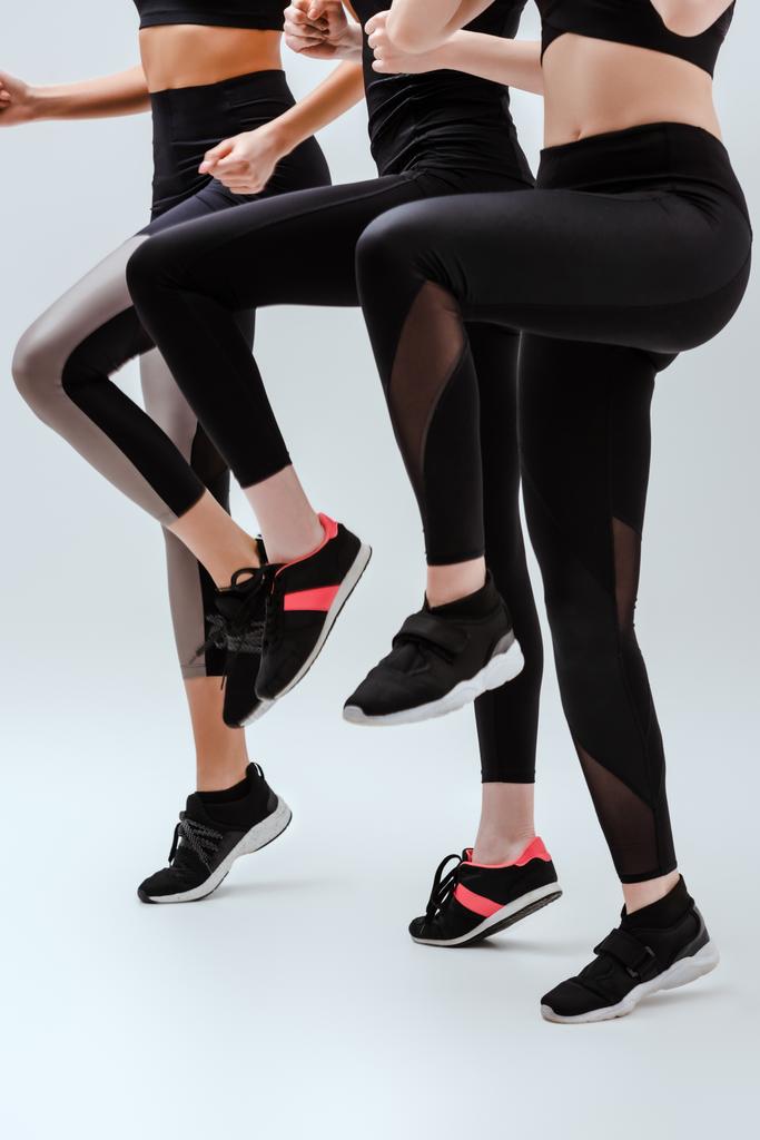 vista cortada de mulheres multiculturais em sportswear exercício em branco
  - Foto, Imagem