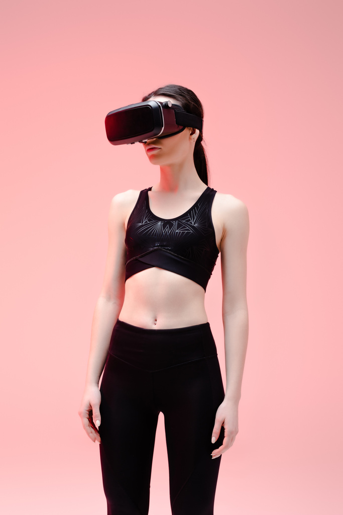 Sportlerin im Virtual-Reality-Headset steht auf rosa   - Foto, Bild
