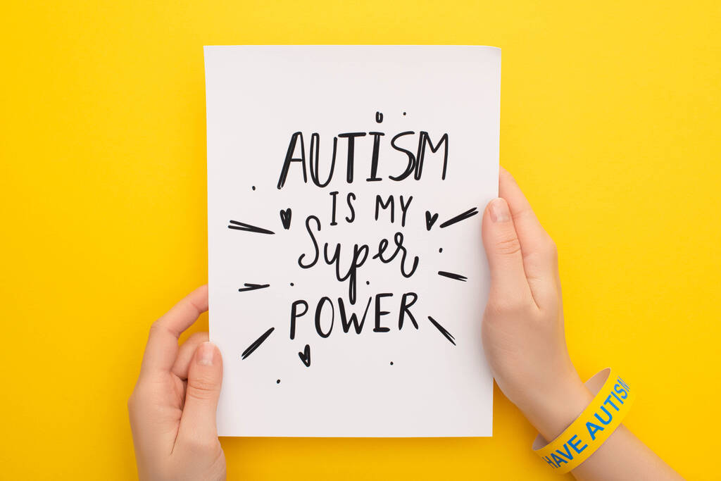 abgeschnittene Ansicht einer Person, die ein Blatt Papier mit Autismus hält, ist meine Supermachtbeschreibung auf gelb - Foto, Bild