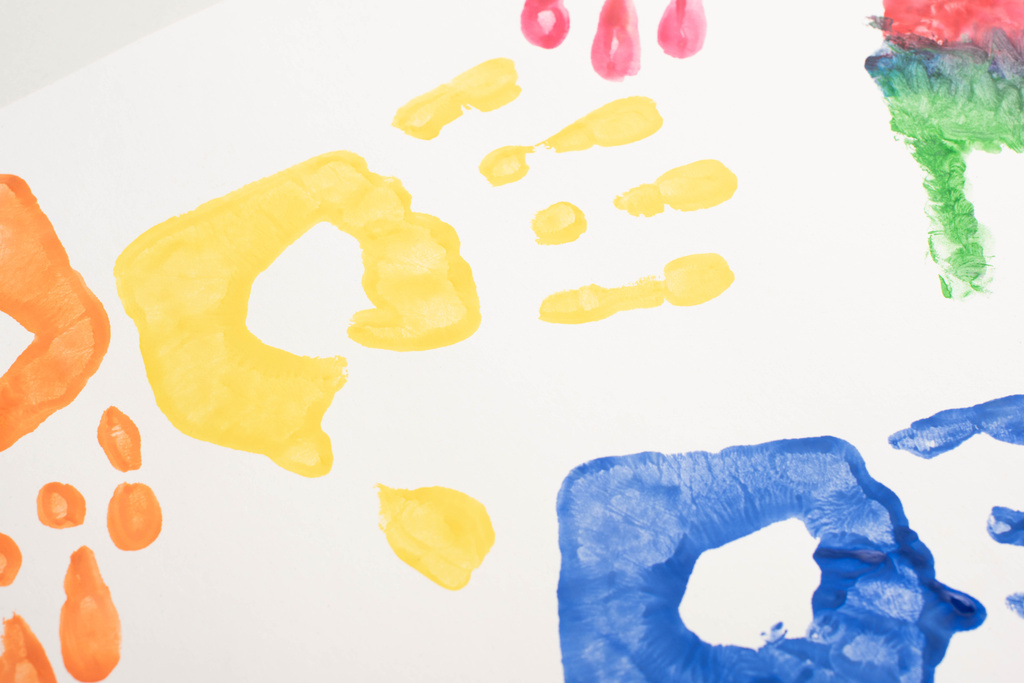 Blick von oben auf bunte Handabdrücke auf Weiß zum Welt-Autismus-Tag  - Foto, Bild