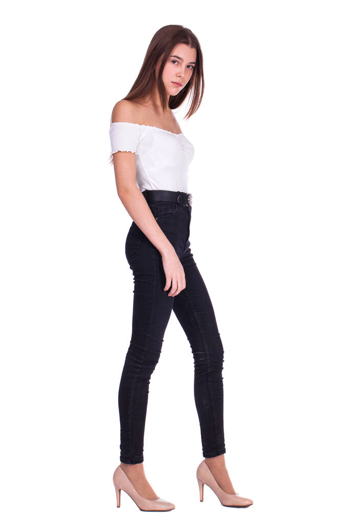 Full body portret van een jonge mooie brunette model in blauwe jeans, geïsoleerd op witte achtergrond - Foto, afbeelding