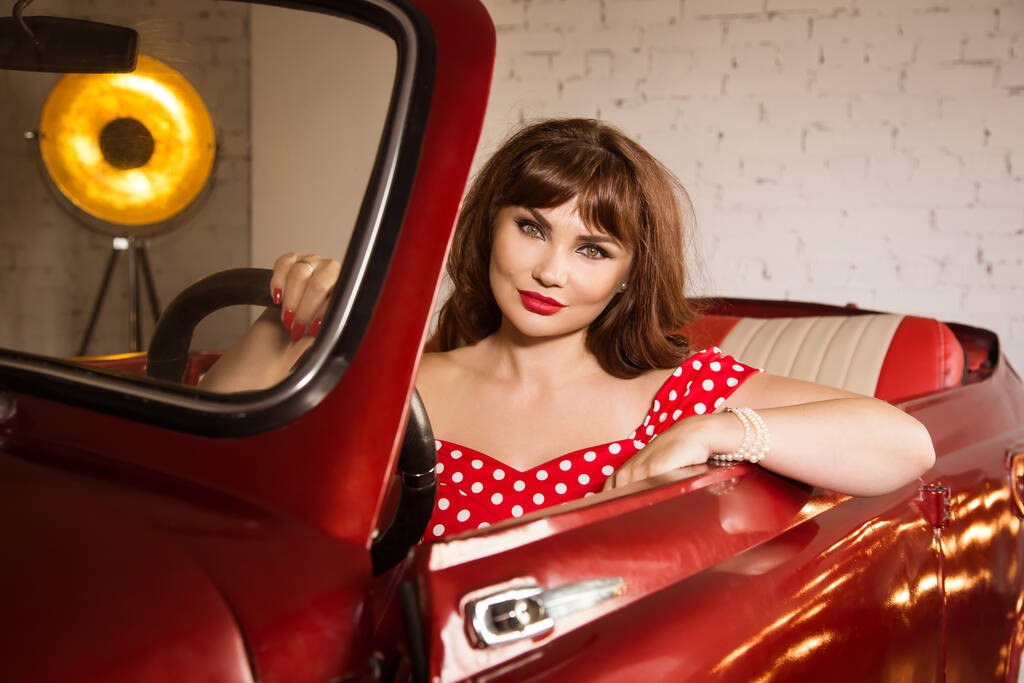 Όμορφη σέξι καρφίτσα επάνω κορίτσι κάθεται στο κόκκινο αυτοκίνητο - Φωτογραφία, εικόνα