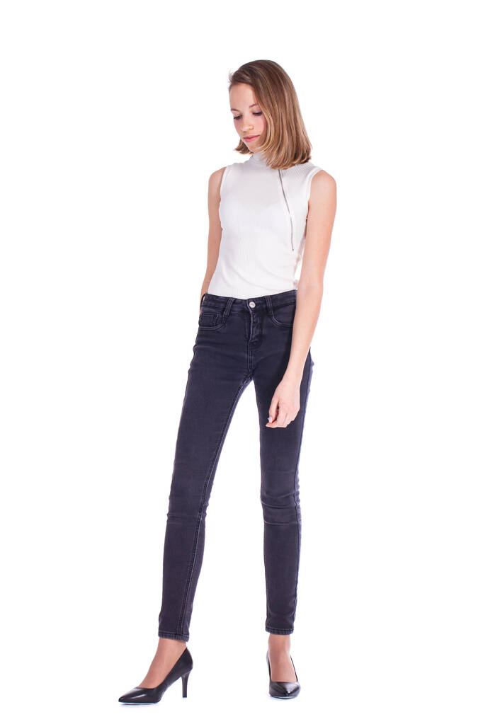 Full body portret van een jong mooi blond model in zwarte jeans, geïsoleerd op witte achtergrond - Foto, afbeelding