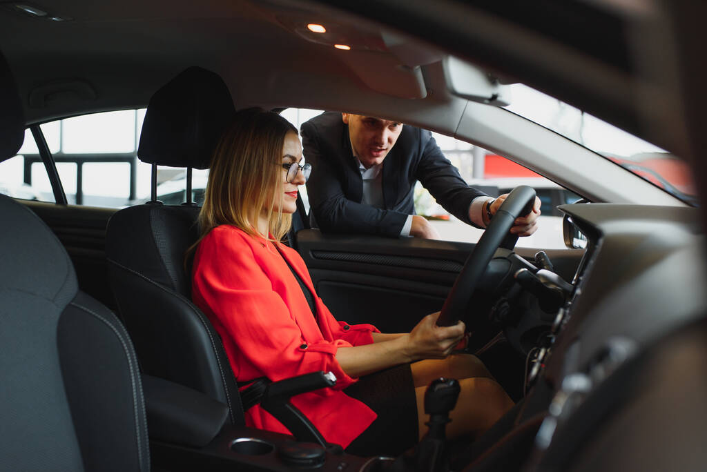 mujer de negocios compra un coche en un concesionario de coches. Concepto de gente de negocios feliz
 - Foto, imagen