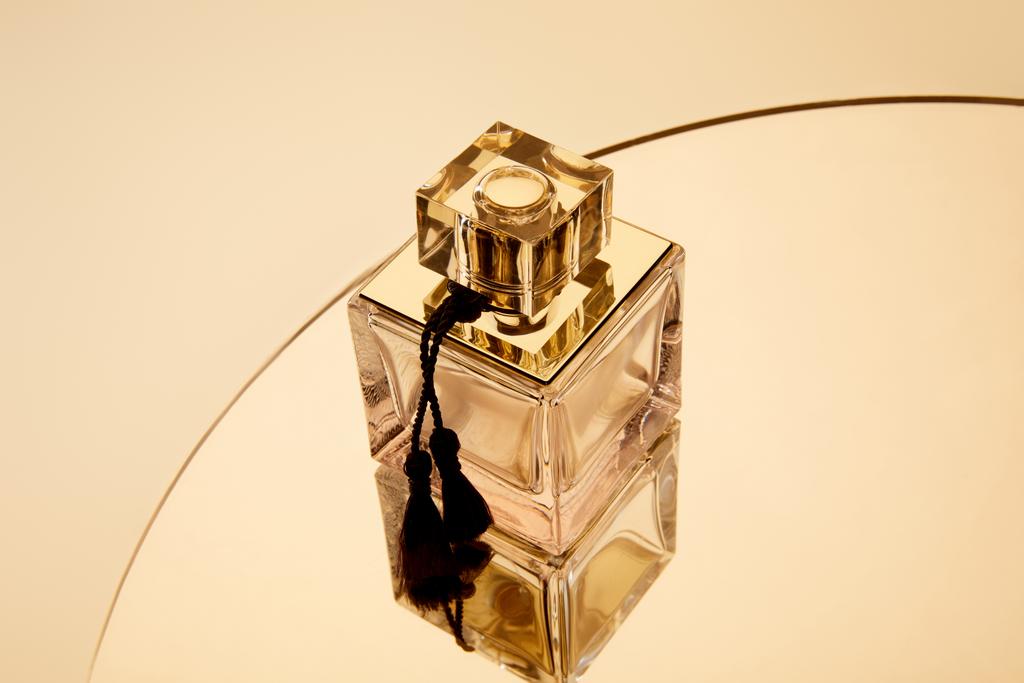 Vue grand angle du flacon de parfum sur une surface miroir ronde dorée
 - Photo, image