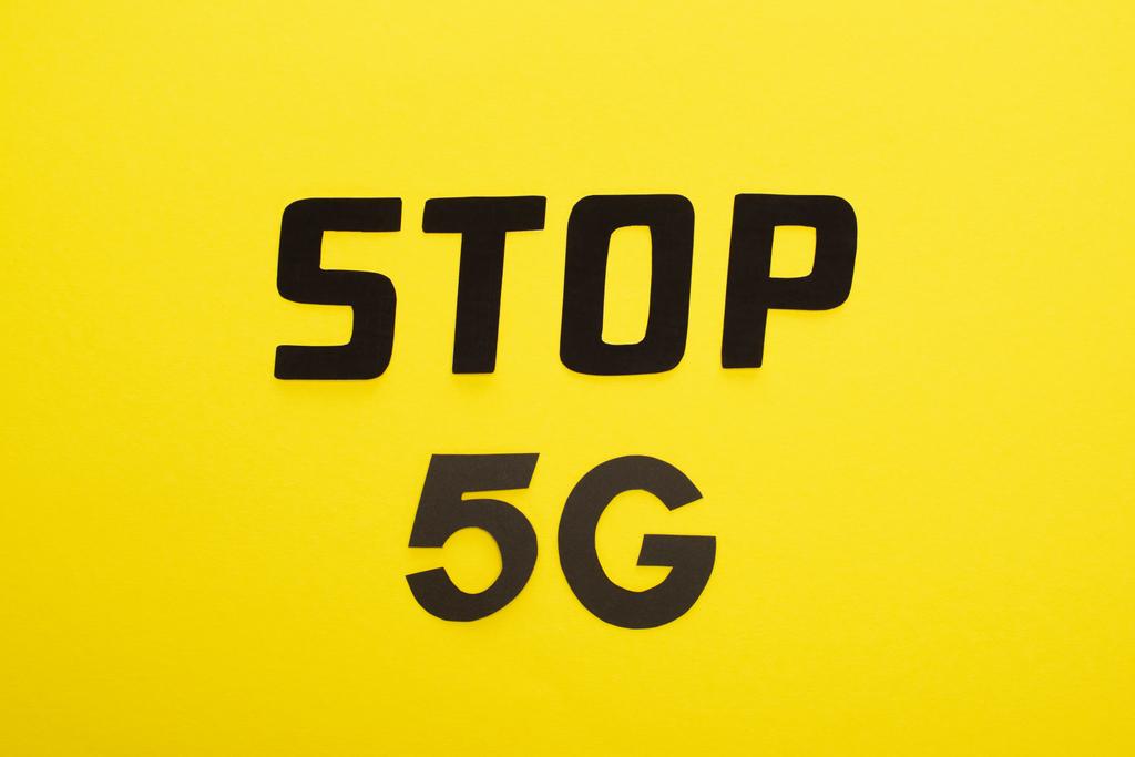 Draufsicht auf Stop 5g Schriftzug auf gelbem Hintergrund - Foto, Bild