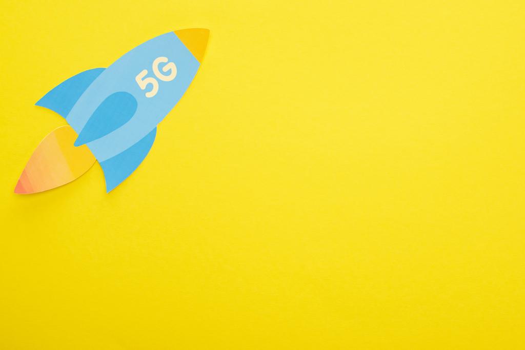 top view of paper rocket with 5g lettering on yellow background - Photo, Image