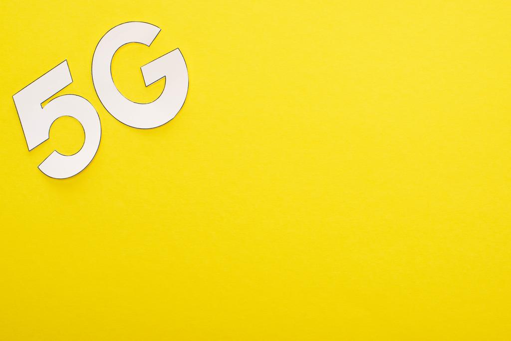 黄色の背景に白い5gの文字のトップビュー - 写真・画像