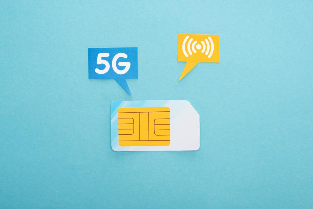 top view of sim card and  speech bubbles with 5g lettering on blue background - Photo, Image