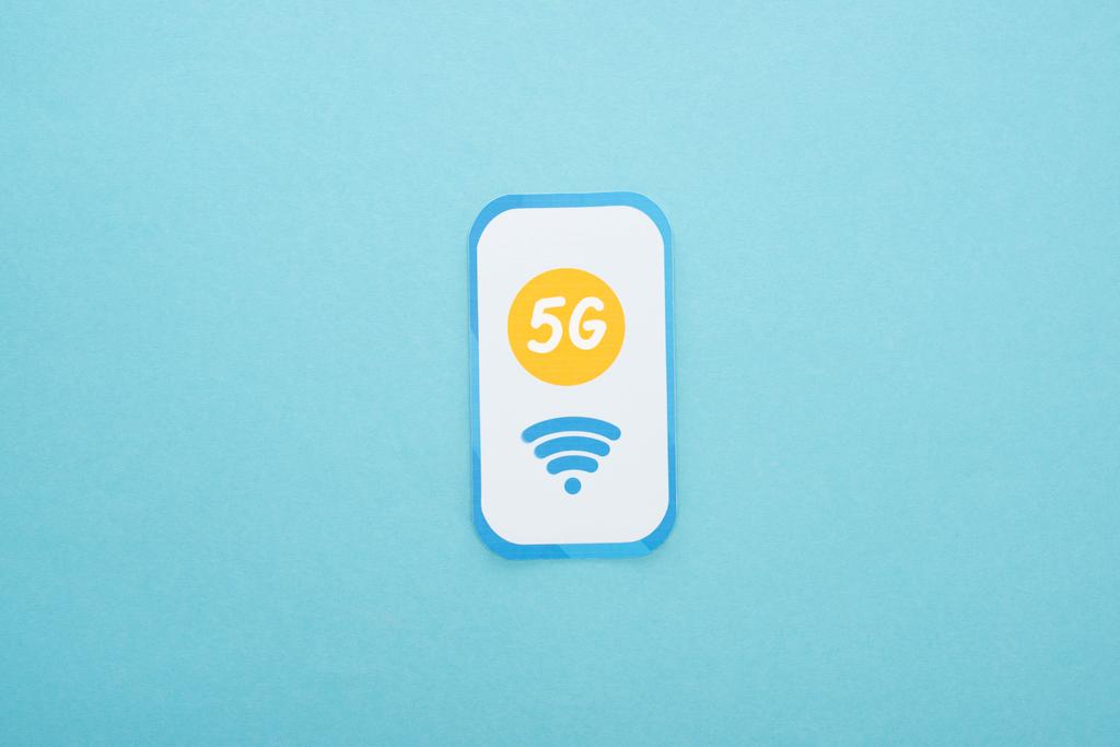 top view of 5g lettering on paper smartphone on blue background - Photo, Image