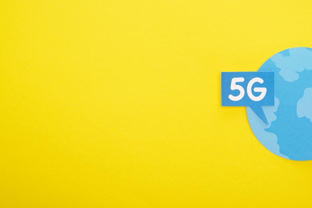 Top view of speech bubble with 5g lettering near blue globe on yellow background
 - Фото, изображение