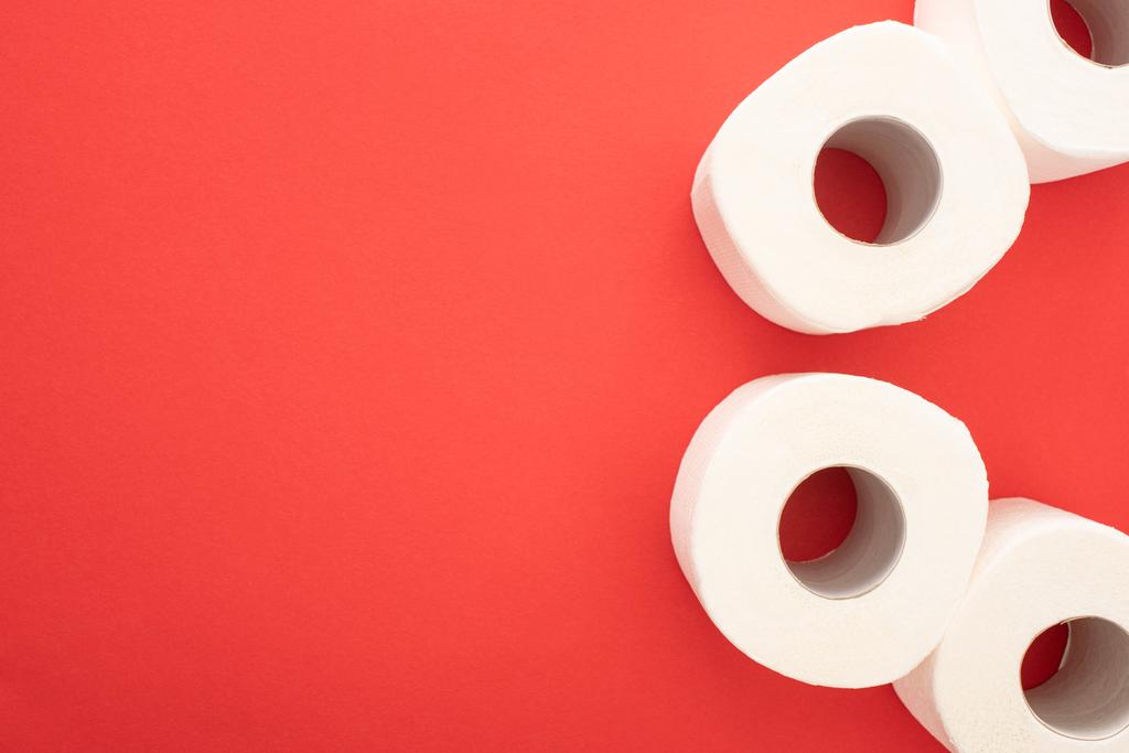 Вид зверху на білий туалет паперові рулони на червоному тлі з пробілом для копіювання
 - Фото, зображення