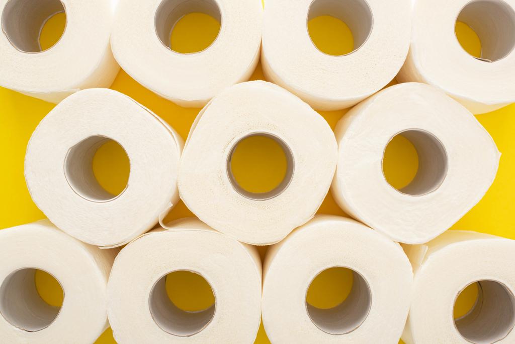vista superior de rollos de papel higiénico blanco sobre fondo amarillo
 - Foto, imagen