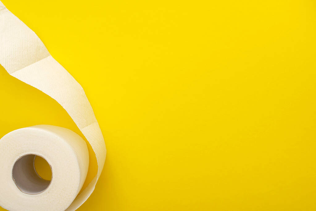 vrchní pohled na bílý toaletní papír role na žlutém pozadí s kopírovacím prostorem - Fotografie, Obrázek