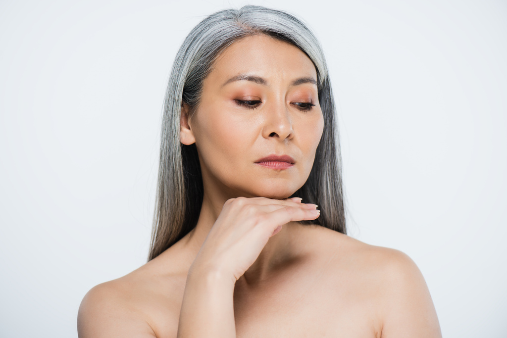 Erwachsene asiatische nackte Frau mit perfekter Haut und grauem Haar isoliert auf grau - Foto, Bild