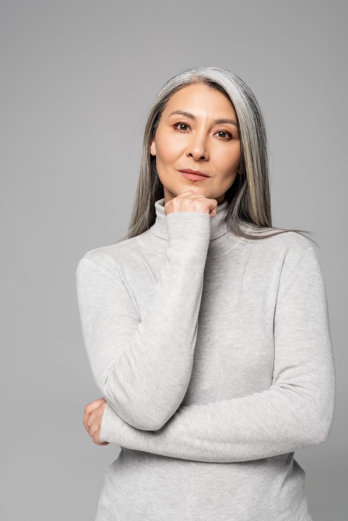thoughtful asian woman in turtleneck with grey hair and closed eyes isolated on grey - Photo, Image