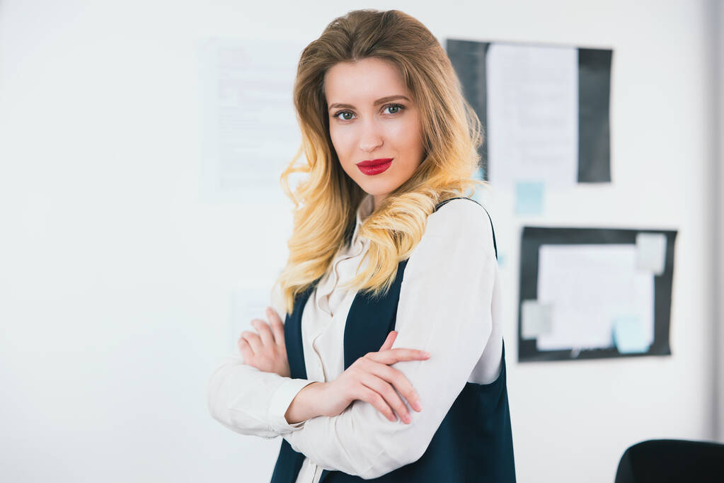 πορτρέτο της νεαρής ξανθιάς όμορφη επιχειρηματίας φορώντας έξυπνο κοστούμι στέκεται στο φωτεινό γραφείο της, έννοια της εργασίας. - Φωτογραφία, εικόνα