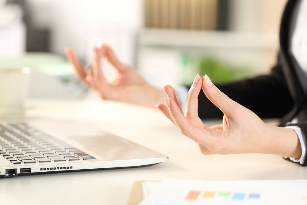 Zbliżenie do wykonawczej ręce stres łagodzenie robi jogi poza siedząc na biurku w biurze - Zdjęcie, obraz