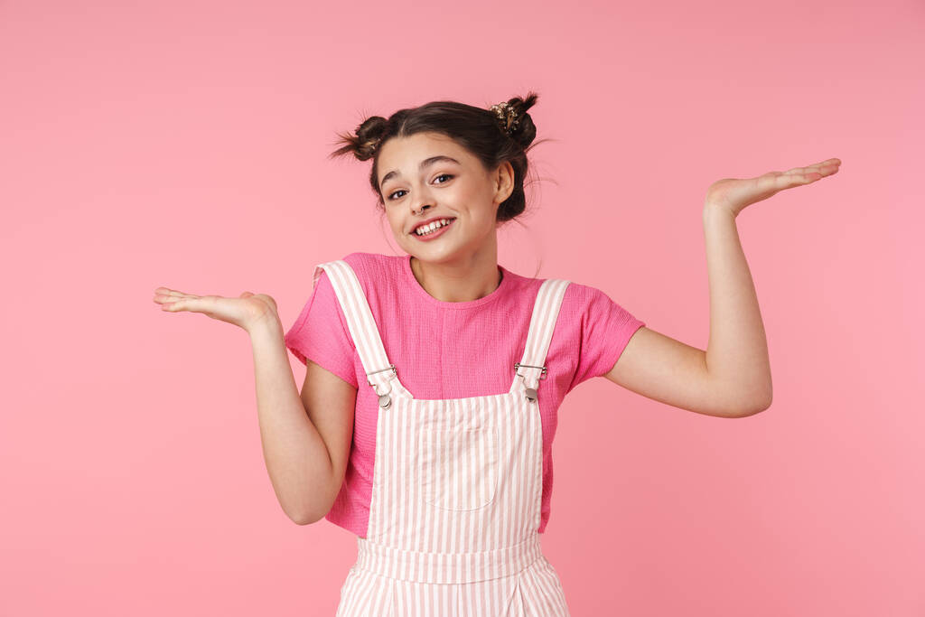 Foto von lustigen charmanten Mädchen mit Nasenring hält Kopierraum und lächelt isoliert über rosa Hintergrund - Foto, Bild