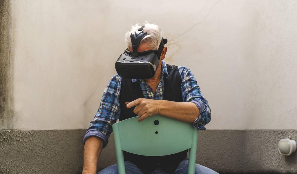 mature man is looking through the viewer of virtual reality during tough quarantine at the time of coronavirus - Photo, Image