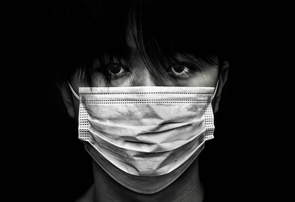 close-up van ernstige kijken aziatisch kind dragen van een gezicht masker - Foto, afbeelding