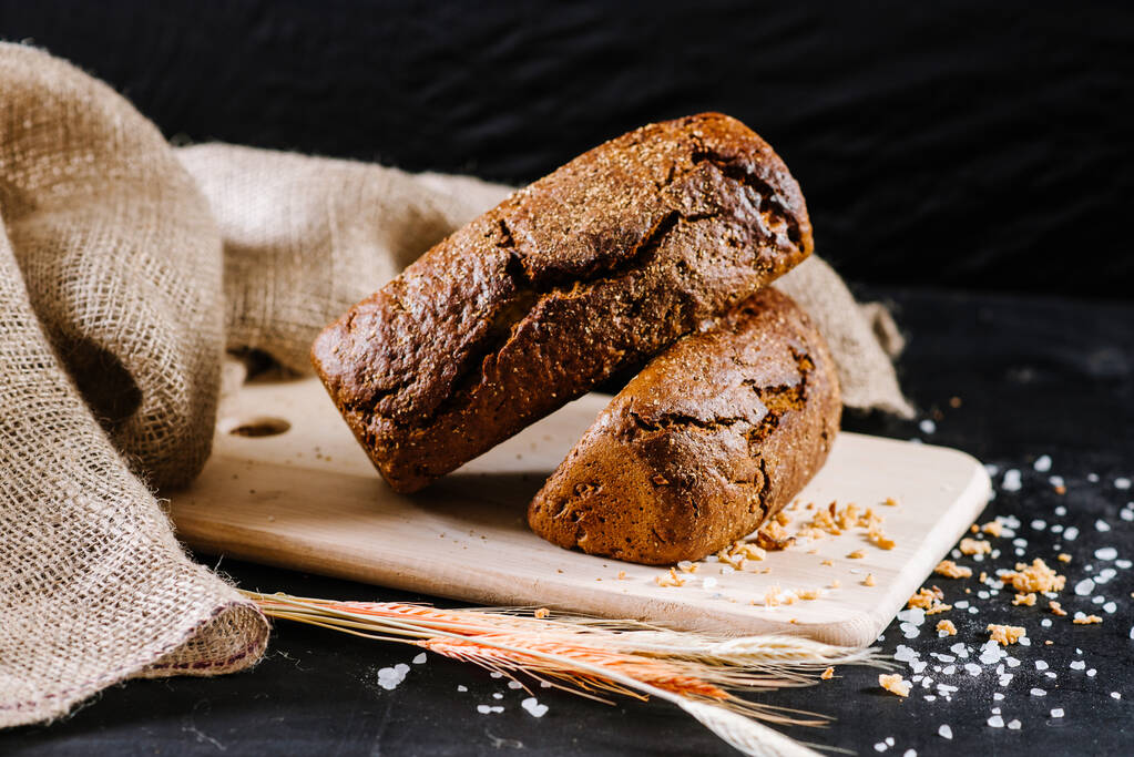 pan y trigo dulce y sabroso sobre fondo de madera negro
 - Foto, Imagen