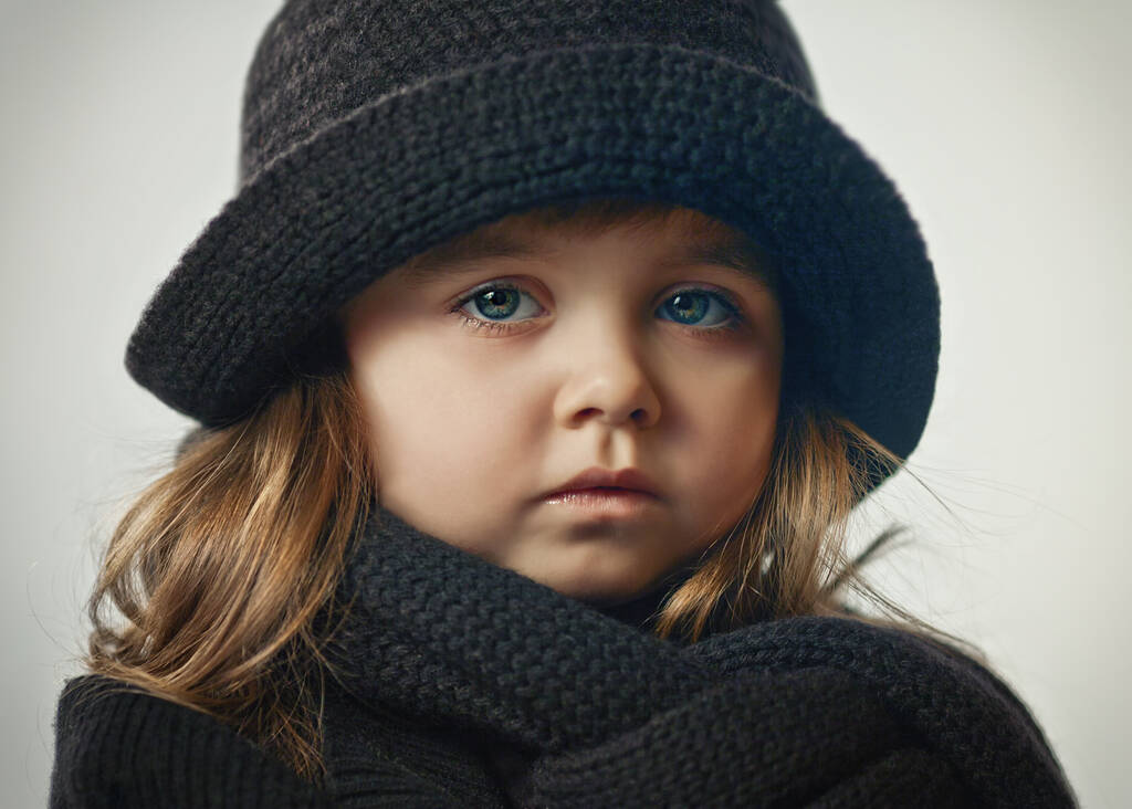 Портрет серьезной маленькой девочки в черной трикотажной одежде
 - Фото, изображение