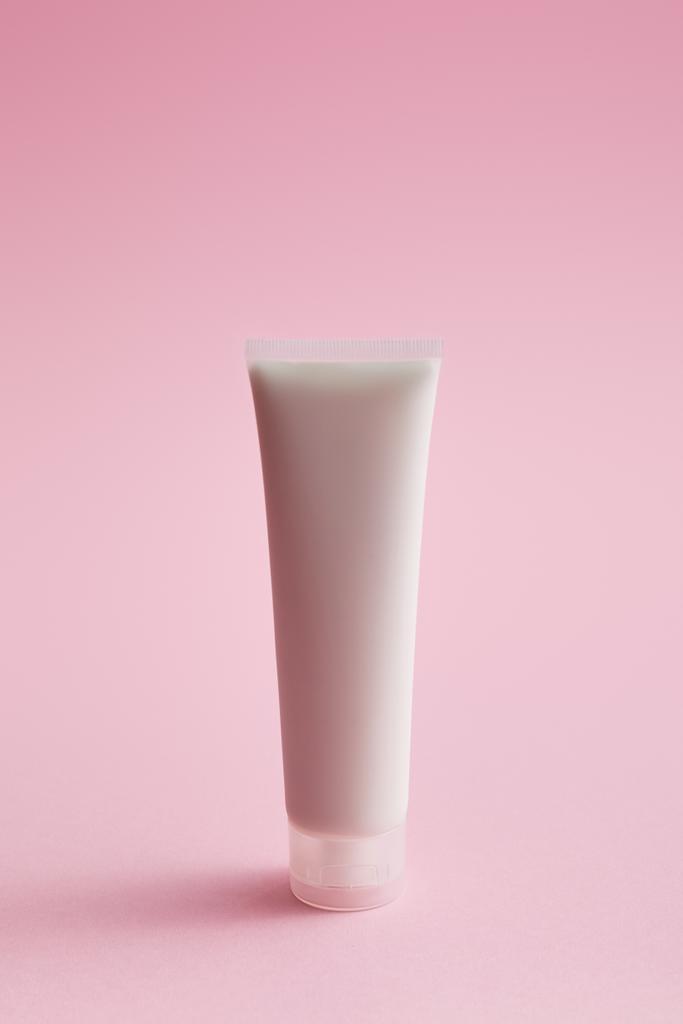 Tubo de crema cosmética de plástico sobre fondo rosa
 - Foto, imagen