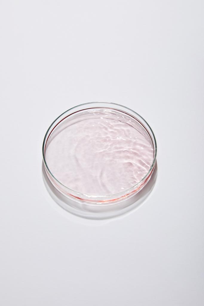 Υψηλής γωνίας όψη εργαστηριακών γυαλικών με ροζ υγρό σε γκρι φόντο - Φωτογραφία, εικόνα