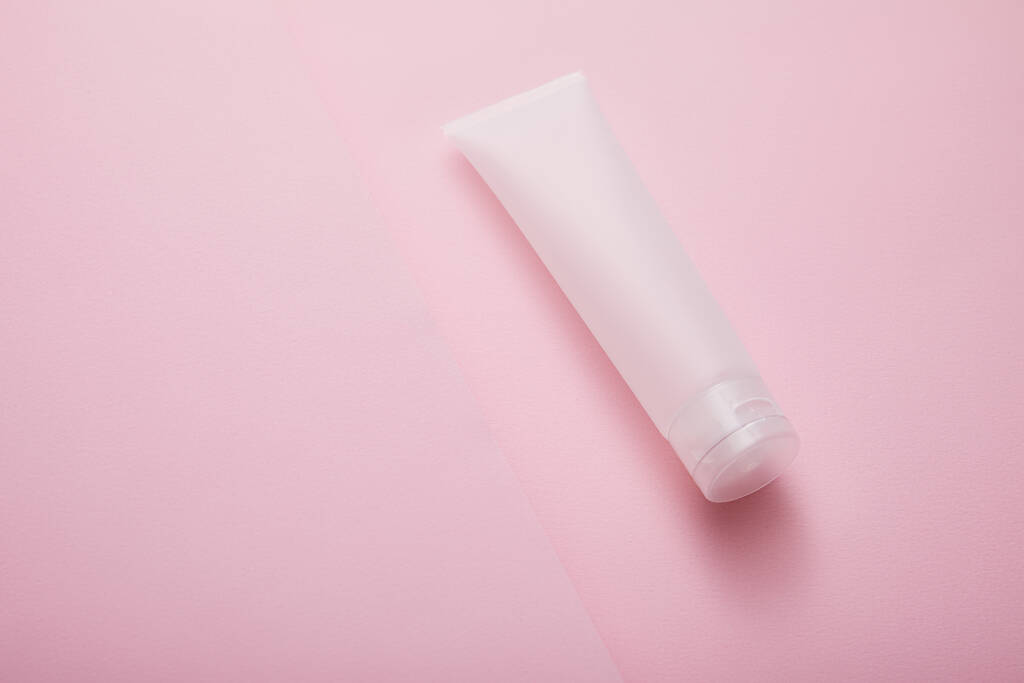 Vue grand angle du tube de crème cosmétique en plastique sur fond rose
 - Photo, image