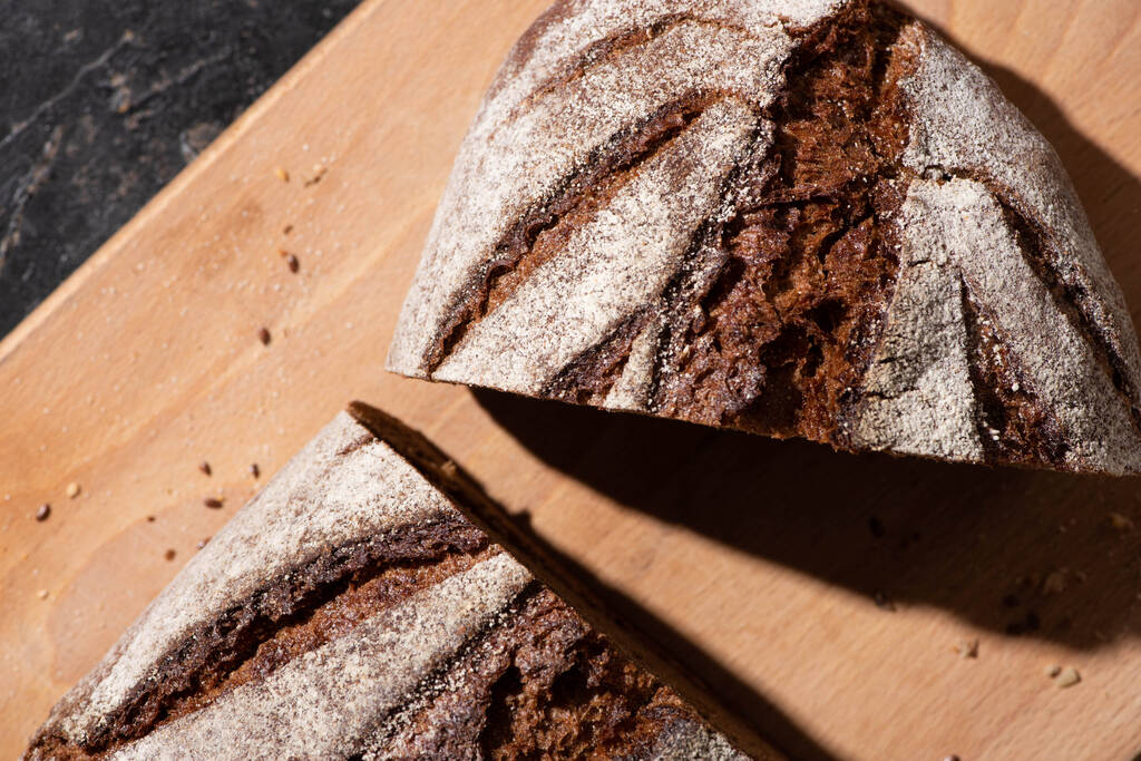 вид зверху свіжого запеченого нарізаного коричневого хліба на обробній дошці
 - Фото, зображення