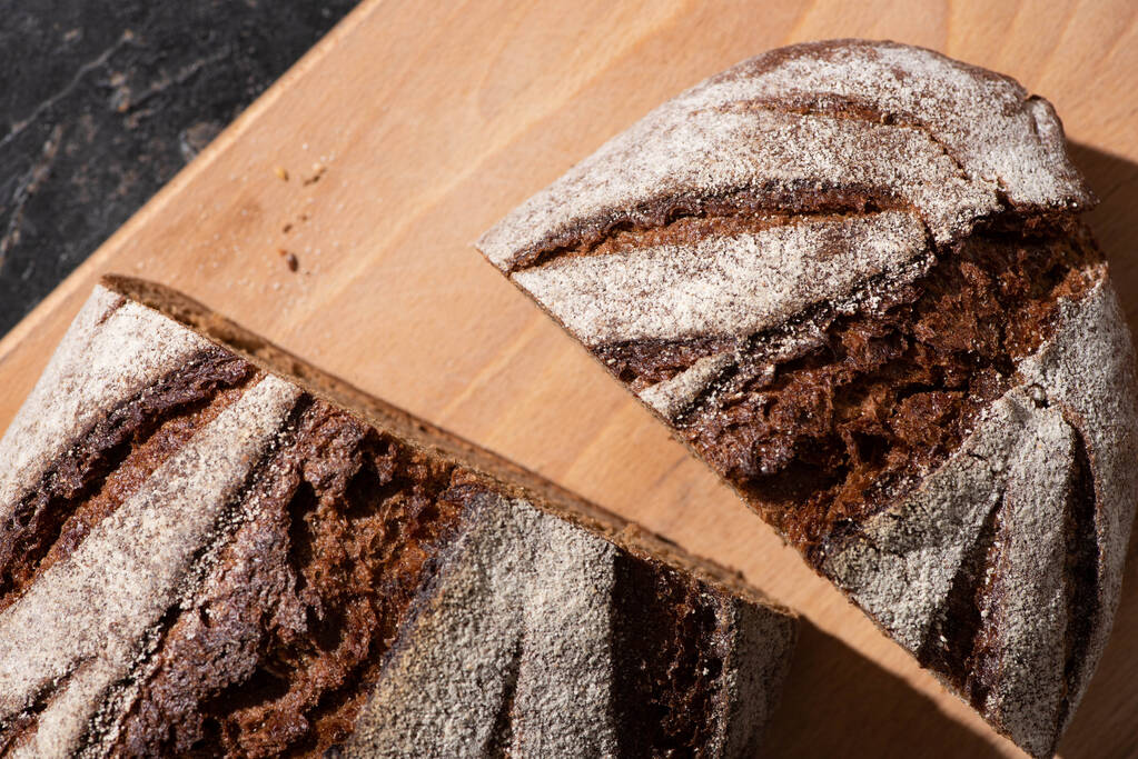 ylhäältä näkymä tuoretta paistettua ruskeaa leipää leikkuulaudalla
 - Valokuva, kuva