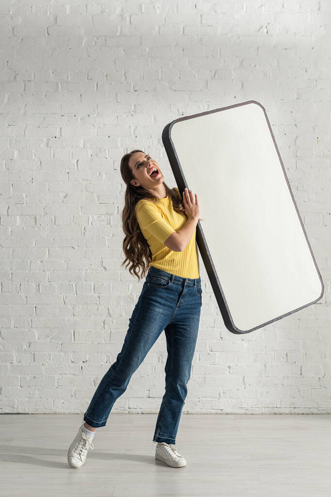 Kaunis naurava nainen tilalla malli älypuhelimen kotona
  - Valokuva, kuva