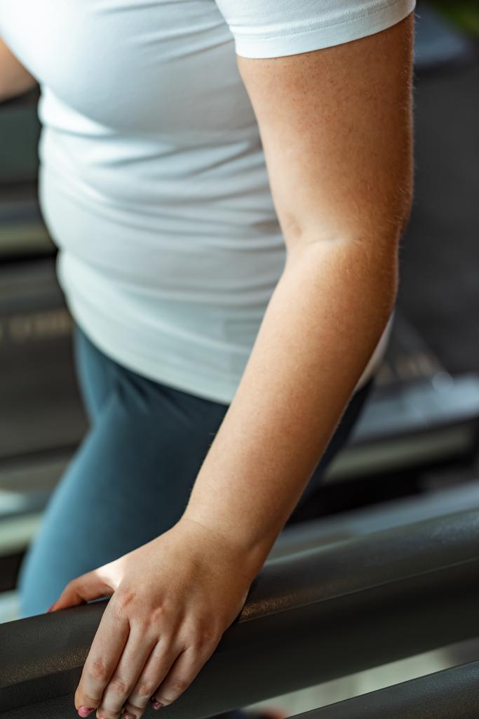 vista recortada de la chica con sobrepeso haciendo ejercicio en el centro deportivo
 - Foto, Imagen